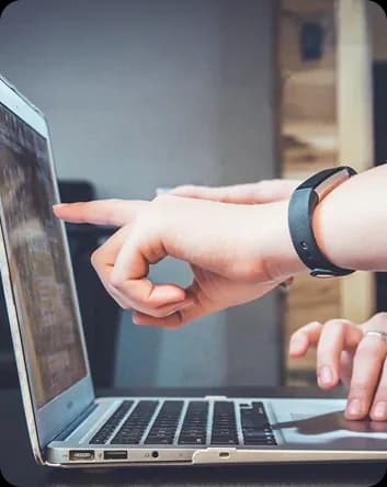 Hai người cùng nhìn vào màn hình laptop, một người chỉ tay vào nội dung đang xem